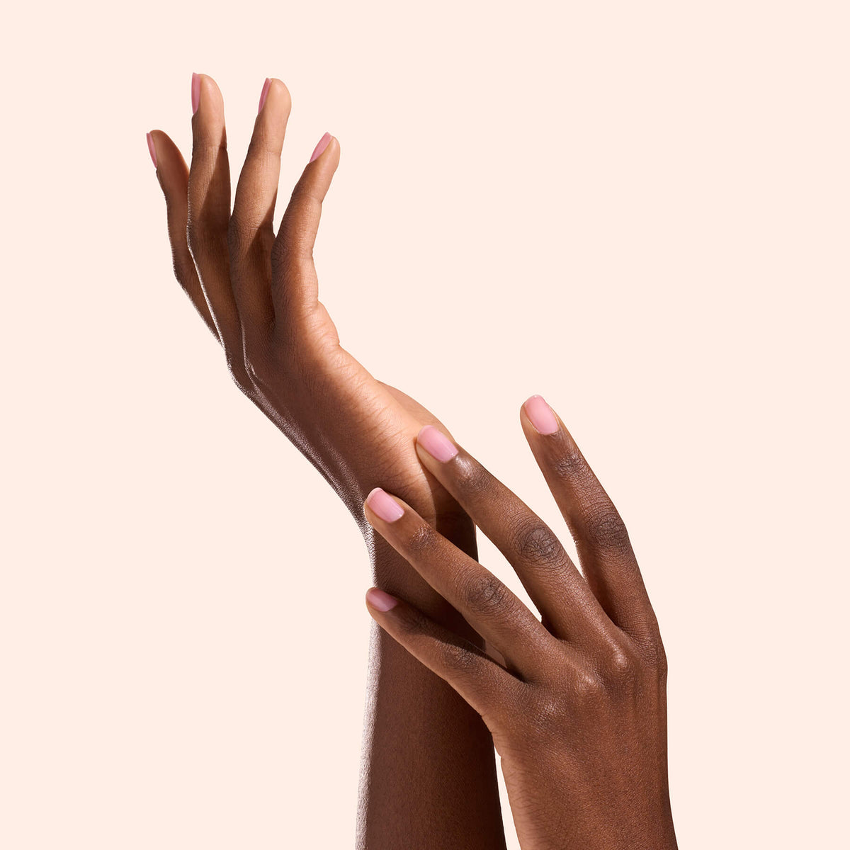 Deux mains aux ongles rose naturel